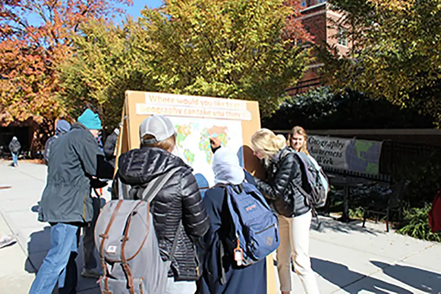 Students pin the places they would like to travel as part of Geography Awareness Week activities on the Burchfiel plaza.