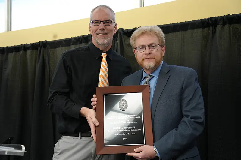 Derek Alderman receives an award from Todd Moore at the Faculty Awards Ceremony